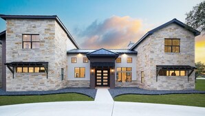 A large, two-story stone house with a central entrance and symmetrical wings. - Near Frio~Pool~Hot tub~Two Kitchens~For 30 (Concan)