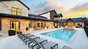 A modern resort with a swimming pool, outdoor seating, and a stone facade. - Near Frio~Pool~Hot tub~Two Kitchens~For 30 (Concan)