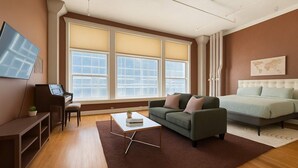 A modern living room with a piano, sofa, and a large bed. - Jazzy Downtown Studio w/ Piano! (Dallas)