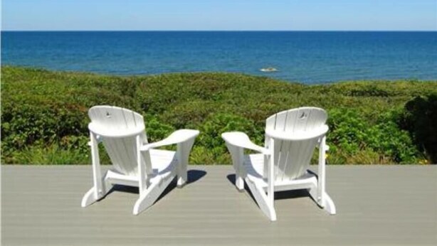 Two white Adirondack chairs facing a view of the ocean. - ''Gulls Way'' - Beachfront and Oceanfront Custom Home on Private Beach (Dennis)