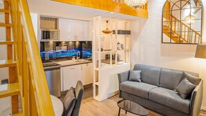 Un intérieur moderne comprenant une cuisine, un coin repas et un escalier menant à un niveau supérieur.