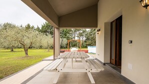 Un espace extérieur abrité comprenant une table de pique-nique et une balançoire.