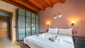 Une chambre à coucher avec un lit, un plafond en bois et une porte-fenêtre coulissante.