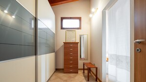 Een hal met een houten dressoir, een kleine tafel en een spiegel.