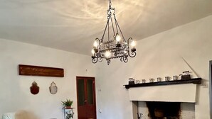 A cozy living room with a wooden dining table, bench, and a fireplace. - Il Podere di Casa Rossa Pienza (Pienza)
