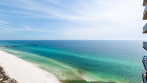 Une plage aux eaux turquoise et limpides, avec une jetée qui s’avance dans l’océan.