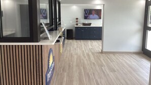 A reception area with a counter, a television screen, and a wall-mounted TV.