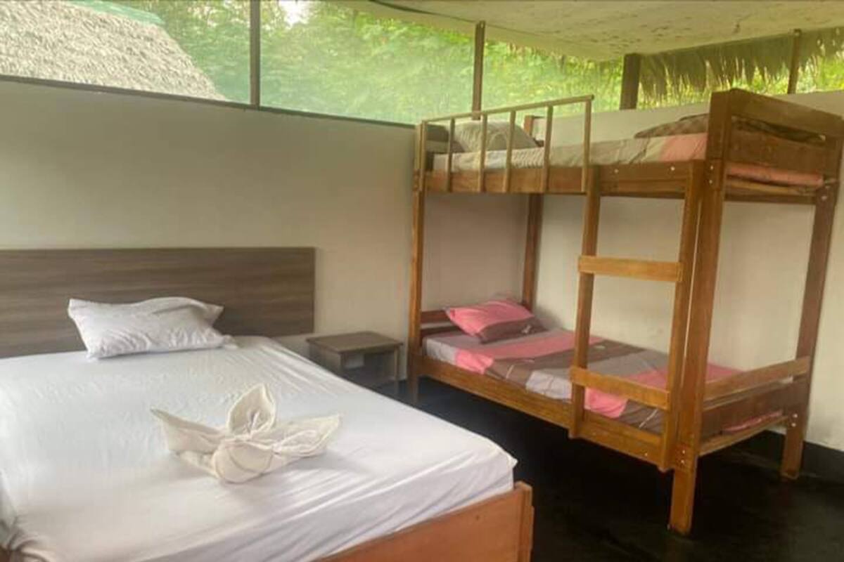 Una habitación con una cama individual, una litera y una mesita de noche.