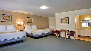 A hotel room with two beds, a desk, a chair, and a mirror. - Travelodge by Wyndham Red Bluff South of Redding (Red Bluff)