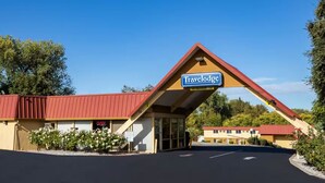 A Travelodge with a red roof, a signboard, and a parking lot. - Travelodge by Wyndham Red Bluff South of Redding (Red Bluff)