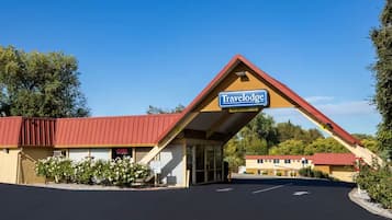 A Travelodge with a red roof, a signboard, and a parking lot.