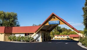 A Travelodge with a red roof, a signboard, and a parking lot. - Travelodge by Wyndham Red Bluff South of Redding (Red Bluff)