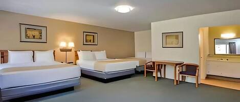 Ein Hotelzimmer mit zwei Betten, einem Schreibtisch und einem Stuhl.