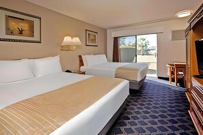 A hotel room with two beds, a TV, a desk, and a large window. - Travelodge by Wyndham Red Bluff South of Redding (Red Bluff)