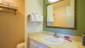 A bathroom with a sink, mirror, towel rack, and toiletries. - Travelodge by Wyndham Red Bluff South of Redding (Red Bluff)