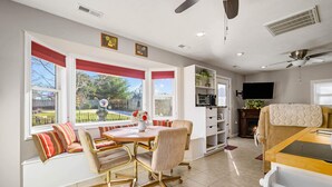 A dining area with a table, chairs, and a view of the backyard. - The Cunningham Cottage | King Bed & Garden (Springfield)