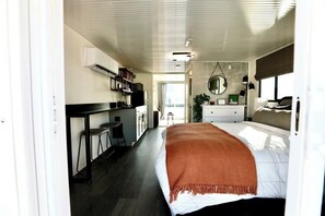 Una habitación de hotel moderna con cama, escritorio y kitchenette.