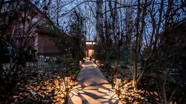 A pathway leading to a building with a warm light source at the end. - Cozy Home:  Close to UT, Smoky Mountains and outdoor fun  (Knoxville)