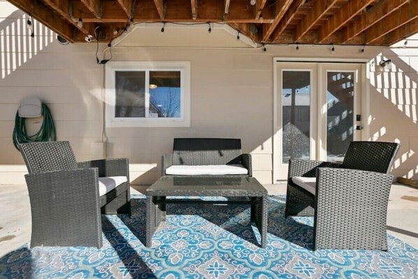 An outdoor seating area with wicker furniture and patterned flooring.