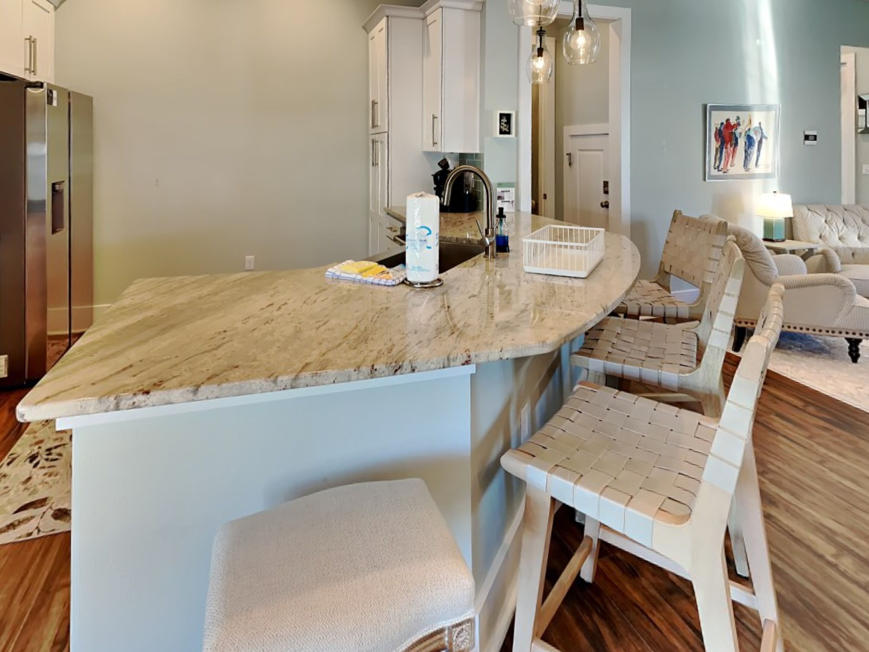 A kitchen with a marble countertop, white cabinets, and a built-in bench.