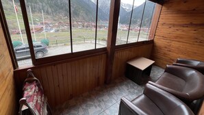 A wooden interior with a view of a mountainous landscape through large windows. - Uzungöl Bikka Pansiyon (Çaykara)