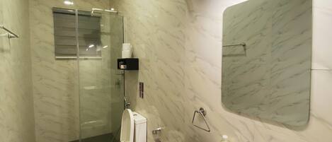 Un baño moderno con inodoro, lavabo y ducha.