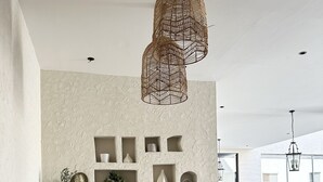 A cozy living room with a textured wall, wicker furniture, and built-in shelves. - Ar Rabi H-10 Royal touch Balcony AG98 (Riyadh)