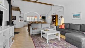 Un vaste espace de vie doté d’un haut plafond, d’une cheminée, d’un coin repas et d’un espace salon confortable.