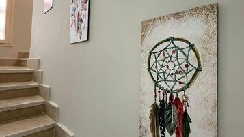 Een trap met een dromenvanger kunstwerk aan de muur.