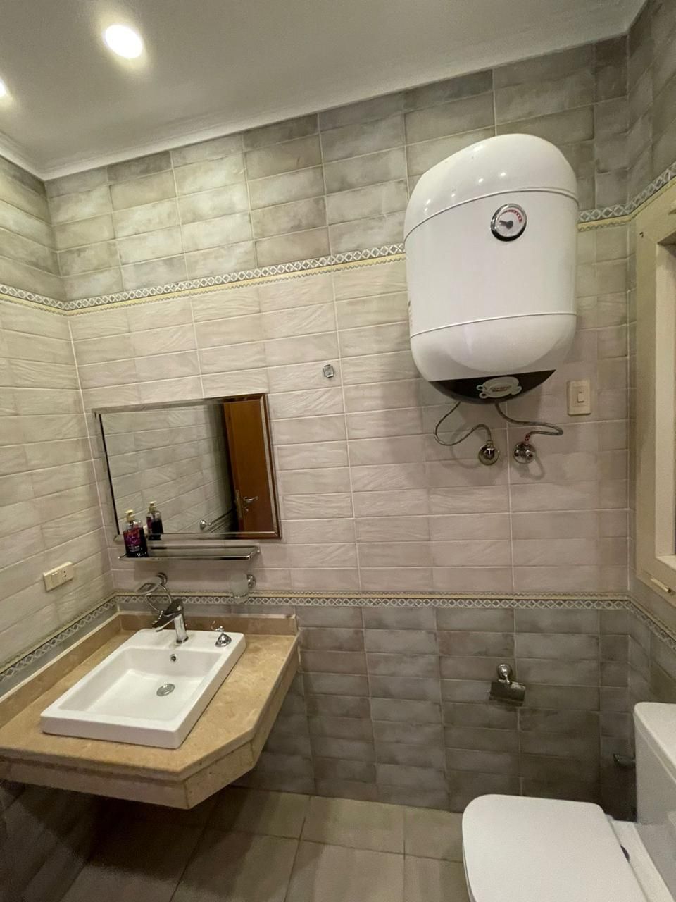 A bathroom with a sink, mirror, and toilet.