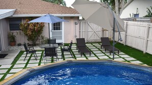 A backyard with a swimming pool, patio furniture, and a covered seating area. - Family Fun, Pool,Theater, Backyard, Early Check-in (Palm Bay)