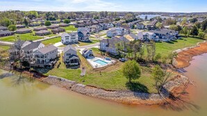 A residential area with houses, a swimming pool, and a river.