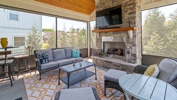 An outdoor patio with a stone fireplace, seating area, and a table.