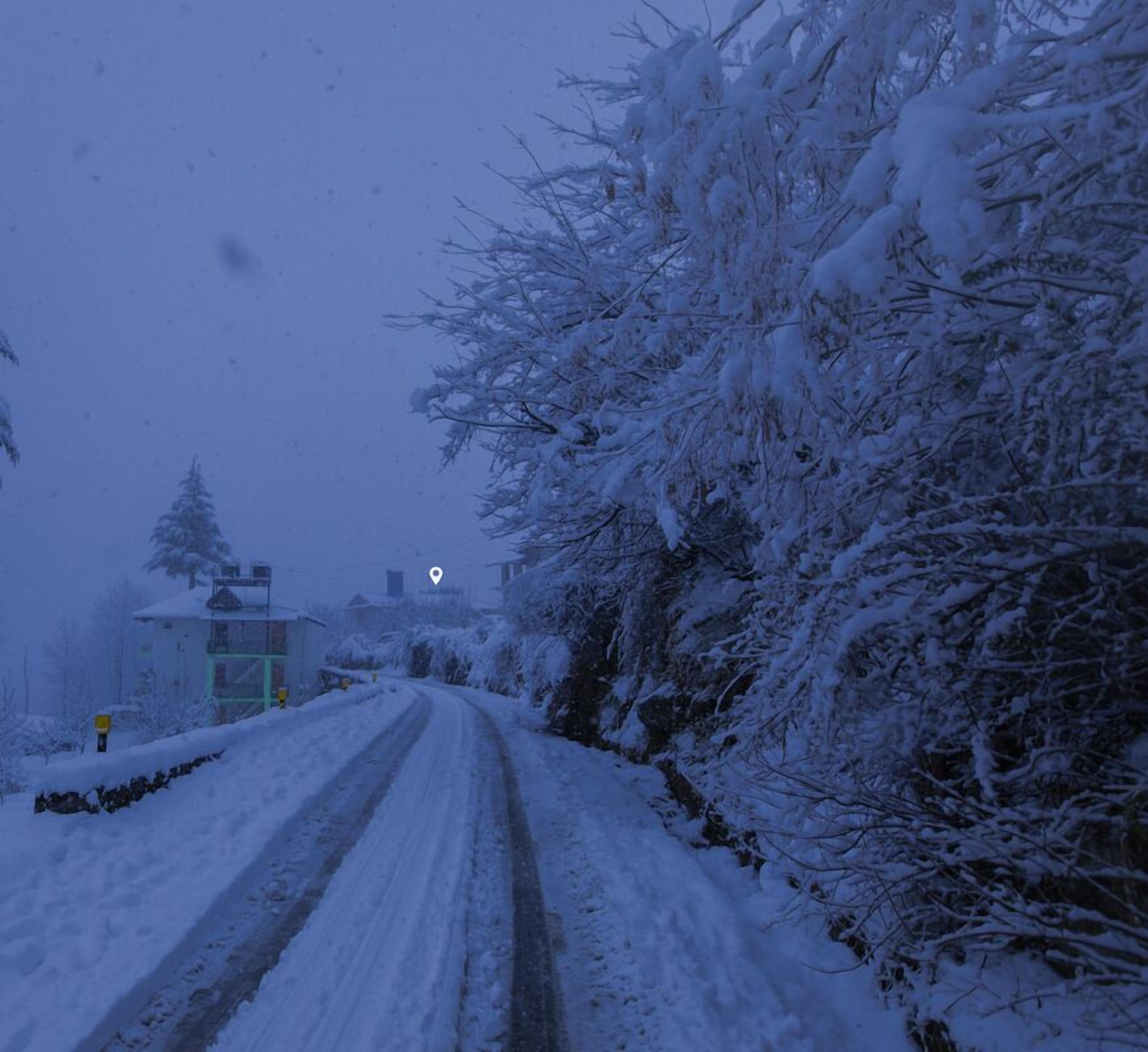 Eine schneebedeckte Straße mit einem Gebäude links.