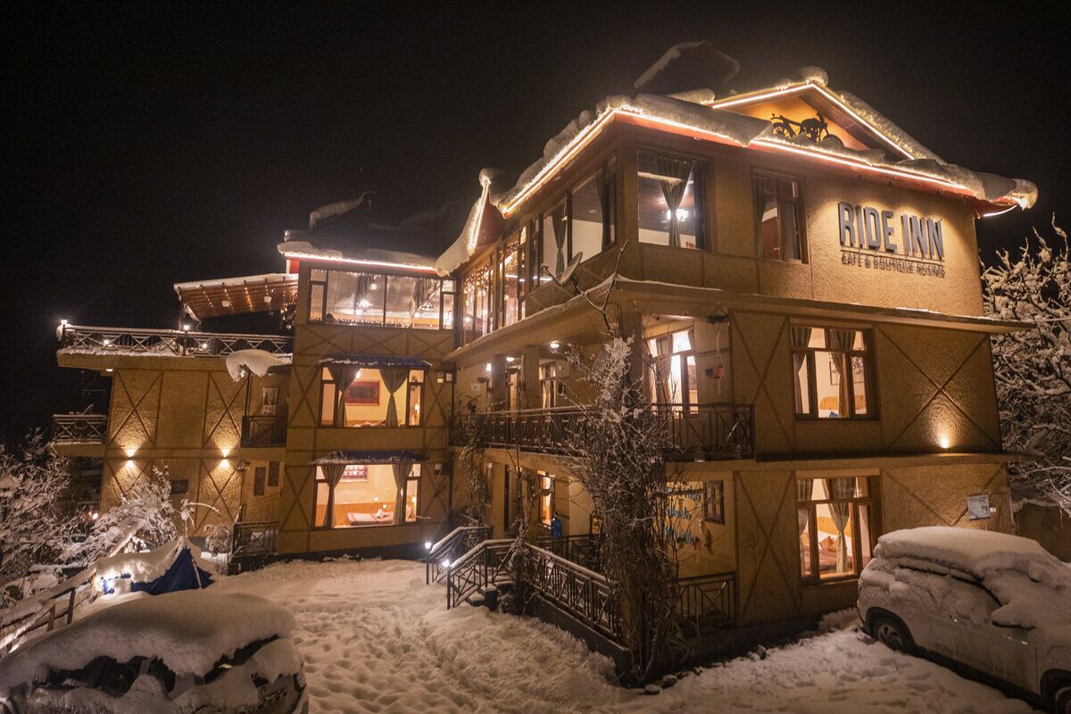A multi-story building with a sign reading "RIDE INN" and a ski lift visible in the background.