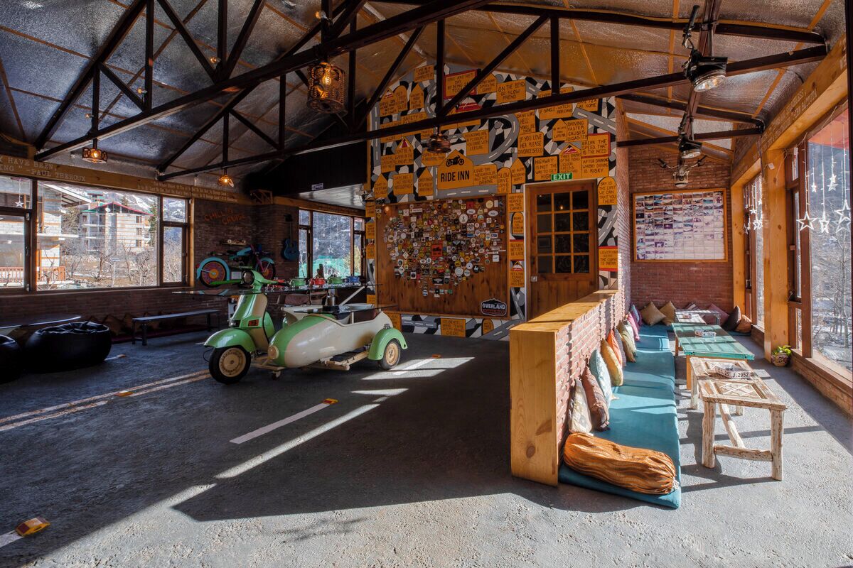 Um interior rústico com uma scooter antiga, móveis de madeira e uma parede decorada com diversos letreiros.