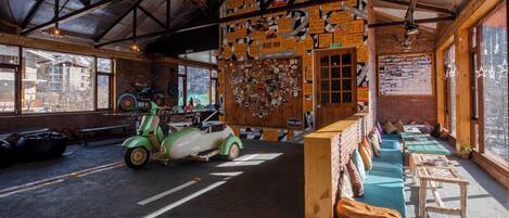 Um interior rústico com uma scooter antiga, móveis de madeira e uma parede decorada com diversos letreiros.