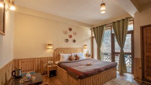 Une pièce confortable avec un lit en bois, une petite table avec une bouilloire et une fenêtre avec des rideaux.