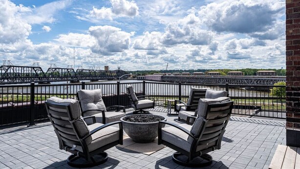 A terrace with outdoor seating and a view of a bridge and river. - The Nelson Lofts - Unit 3 (2 BR) (Davenport)