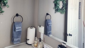 A bathroom with a white sink, black faucets, a mirror, and a towel rack. - 3 bedroom 1 bath above garage guest house (Shoshone)