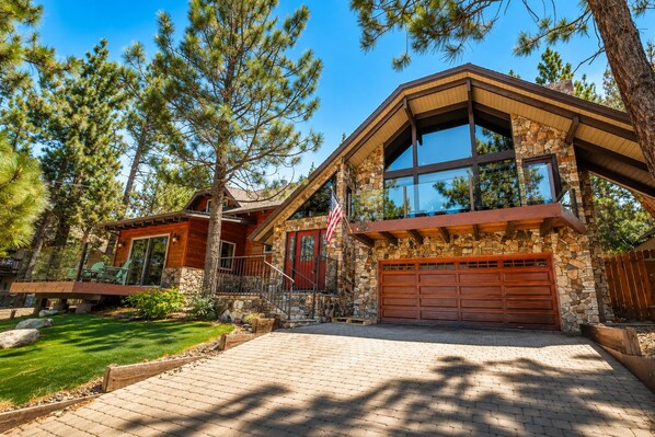 A modern house with a stone facade, large windows, and a garage.