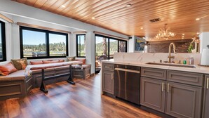 Una cocina moderna con armarios de madera, lavavajillas integrado y un amplio ventanal con vistas a un paisaje pintoresco.