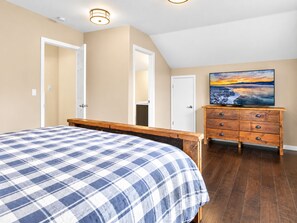 Ein Schlafzimmer mit einem Bett, einem Schminktisch und einem Bild an der Wand.