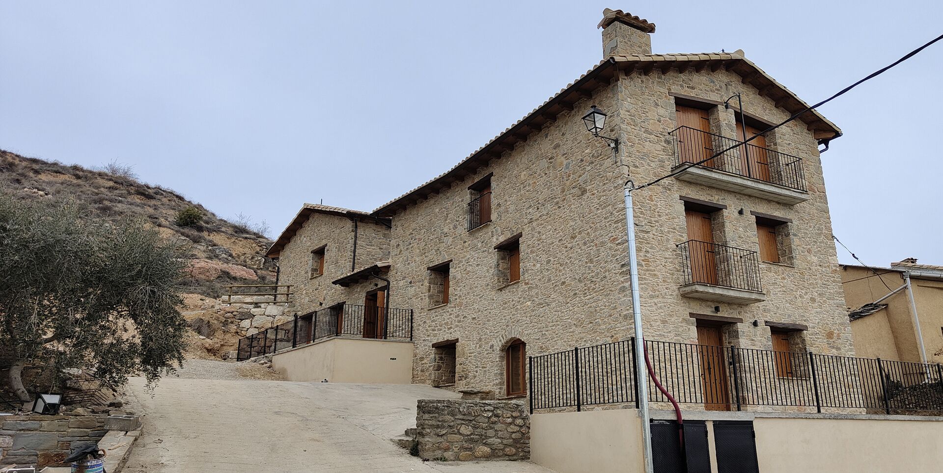 Un edificio de piedra con varios balcones y una escalera que lleva a la entrada.