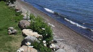 A coastal path with a rocky shoreline, a clear blue sky, and distant mountains. - St Francis Townhome with Amenities, near the lake (Tahoe City)