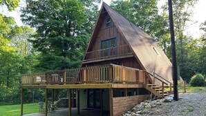 A wooden cabin with a balcony and a covered porch. - Wild Ivy Cottage A-Frame (Rockville)
