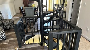 A staircase with a black railing and a wooden floor. - Wild Ivy Cottage A-Frame (Rockville)