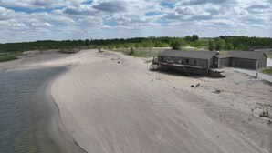 A sandy beach with a house and a dock.