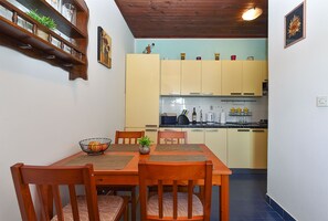 Enjoy meals in this cozy kitchen and dining area, featuring a wooden table and modern appliances.