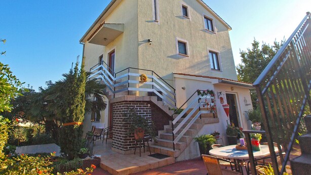 A two-story house with a balcony, a staircase, and a patio area with outdoor furniture. - Apartment 2317/108186 (Istria - Premantura), 300m from the beach (Premantura)